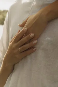 Close-up of hands showing affection on a person's chest conveying warmth and intimacy.